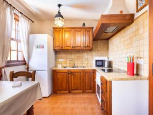 a kitchen with wooden cabinets and a white refrigerator at Live Arico El Mirador in Arico el Nuevo