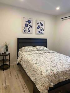 a bedroom with a bed and two paintings on the wall at Peaceful and Heavenly Private Water Front Cottage on 100 Acres of Scenic Beauty- Trent Lakes in Kinmount