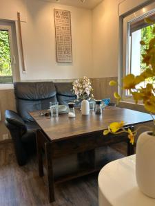 a living room with a wooden table and a couch at Charmantes Tiny Haus mit 2 Wohnungen in Nümbrecht