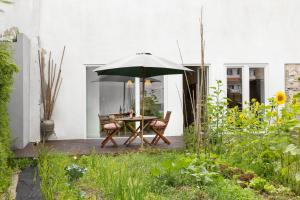 a patio with a table and an umbrella at Quintal Orgânico in Vau