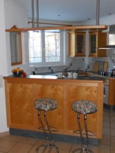 eine Küche mit zwei Barhockern an der Theke in der Unterkunft Haus Handle in Grins