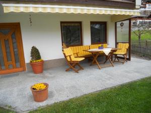 un patio con mesa y sillas junto a una casa en Haus Handle, en Grins