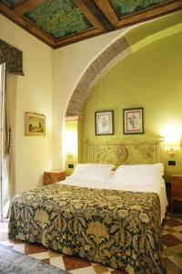 a bedroom with a large bed with an archway at Albergo delle Drapperie in Bologna +113 photos