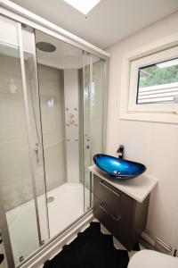 a bathroom with a blue sink and a shower at Evenes Artic glamping in Evenesmarkja