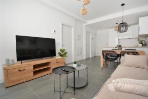 a living room with a flat screen tv on a wooden entertainment center at GALIHOST - Apartamento en Playa de Compostela in Vilagarcia de Arousa +6 photos