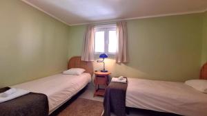 zwei Betten in einem Zimmer mit Fenster in der Unterkunft Costa do Castelo Terrace, em Rua dos Lagares 8 in Lissabon