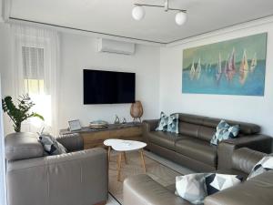 a living room with two leather couches and a flat screen tv at Villa Field6 in Révfülöp