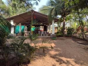 ein Haus mit einer Veranda mit Palmen in der Unterkunft Annapurna beach resort in Malvan