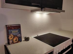 een boek dat op het aanrecht naast het fornuis ligt bij Rummelig lejlighed - i Dronninglund in Dronninglund