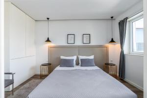 a bedroom with a large bed with two pillows at Angel Flats in Porto