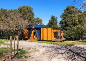 a tiny house with a blue roof on a lot at Hillside Hideaway Cabin in Knysna