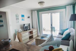 a living room with a couch and a tv at Baydream Away in Cape Town