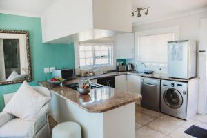 a kitchen with a sink and a dishwasher at Baydream Away in Cape Town