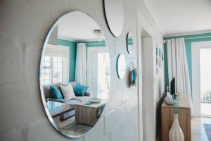 a mirror reflecting a living room with a couch at Baydream Away in Cape Town