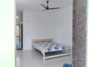 ein Schlafzimmer mit einem Bett in einem weißen Raum in der Unterkunft Annapurna beach resort in Malvan