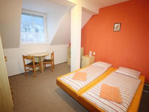 a bedroom with a bed with an orange wall at Penzion Bradlecký mlýn in Bradlecká Lhota