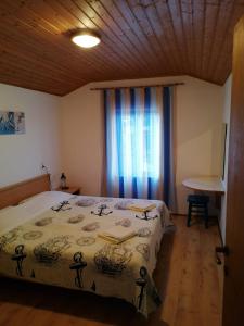 a bedroom with a bed in a room with a wooden ceiling at House ViEn in Nerezine +10 photos