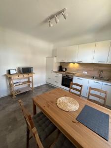 a kitchen with a wooden table and a kitchen with white cabinets at Haus Anna in Freudenstadt