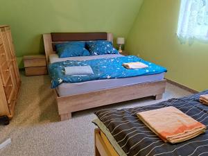 a bedroom with two beds with blue comforters at Domek letniskowy Werlas Bieszczady in Werlas