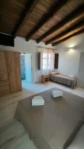 a large room with a bed and a room with two tables at L'Ulivo Affittacamere Gonnosfanadiga in Gonnosfanàdiga
