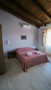 a bedroom with a large bed with two towels on it at L'Ulivo Affittacamere Gonnosfanadiga in Gonnosfanàdiga +50 photos