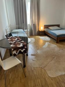 un soggiorno con 2 letti e un tavolo in vetro di Szenetreff City a Würzburg