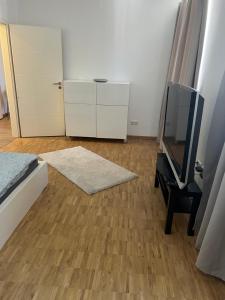 una camera da letto con TV, cassettiera e specchio di Szenetreff City a Würzburg