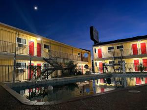 a building with red doors and a reflection in a puddle at Ladybird Inn in Johnson City