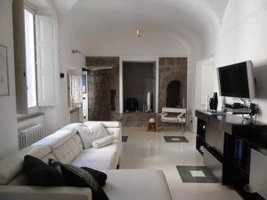a living room with a white couch and a tv at Around the Medieval Tower in Viterbo