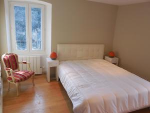 1 dormitorio con 1 cama, 1 silla y 1 ventana en Saint Christophe, en Omessa
