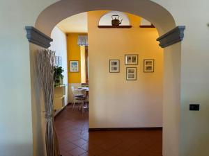 a hallway with an archway and a dining room at Giardino Concordia Apartment in Lucca