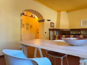 a kitchen with a table and two white chairs at Giardino Concordia Apartment in Lucca +26 photos