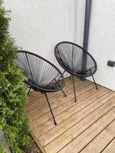 two black chairs sitting on a wooden deck at Loftas Smilga in Palanga