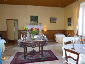 a dining room with a table with flowers on it at Château des Salles in Saint-Fort-sur-Gironde