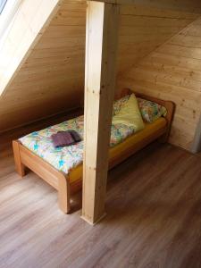 a small bed in a wooden attic room at Apartman Golub Sevojno in Užice