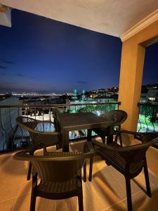 un patio con tavoli e sedie su un balcone di notte di Tarihi Asansör Sokağında Daire a Smirne