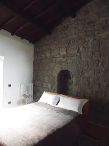 a bedroom with a bed in a stone wall at Around the Medieval Tower in Viterbo