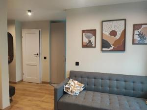 a living room with a couch and pictures on the wall at Žemaičių 8 in Kretinga