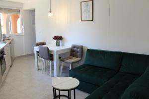 a living room with a green couch and a table at Apartman Collis in Međugorje