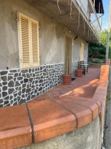 a porch of a house with a stone wall at Casa dolce casa in Gorfigliano