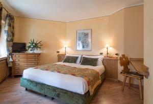 a bedroom with a bed and a desk and a television at Hotel Da Compagnoni in Breuil-Cervinia