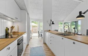 a kitchen with white cabinets and wooden counter tops at 4 Bedroom Nice Home In Ebeltoft in Ebeltoft