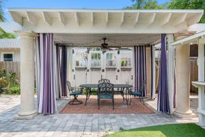 un patio con mesa y sillas bajo un pabellón en Spacious Hyde Park Retreat on Packwood, en Tampa