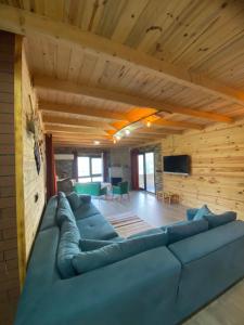 a living room with a large blue couch in a room at Mira Suit Apart in Çamlıhemşin