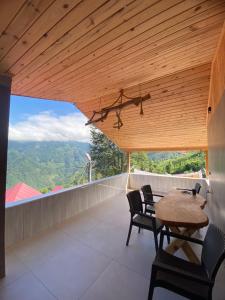 a room with a table and chairs on a balcony at Mira Suit Apart in Çamlıhemşin