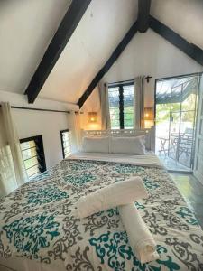 a bedroom with a large bed with a green and white bedspread at Beach Haven! Cozy Cottage in Mombasa +10 photos
