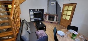 un salon avec une table et une cheminée dans l'établissement Domek w Murzasichlu z kominkiem, à Murzasichle 13 autres photos