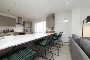 a kitchen with a bar with chairs and a couch at Luxury Duplex 2-Bed Apartment Fruit Market Marina in Hull