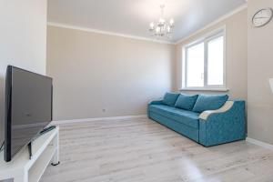 a living room with a blue couch and a tv at Kamal Apart in Prigorodnyy