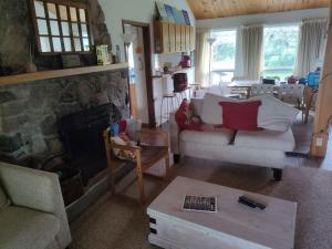 un salon avec un canapé et une cheminée dans l'établissement Cottage on the Pond, à Millbrook